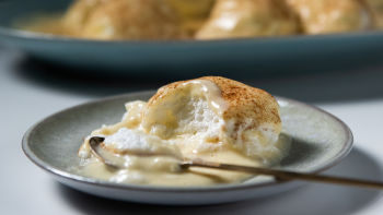 Bolo de queijo de brownie caseiro em chapa branca, decorado com morangos,  mirtilo e cereja, no jogo americano estilo inglês, na mesa de madeira.  usado para decorar a loja.