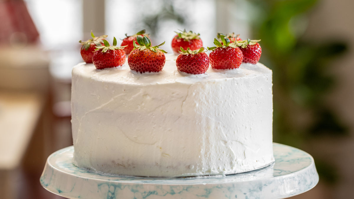 Bolo de baunilha em camadas rosa com chantilly rosa